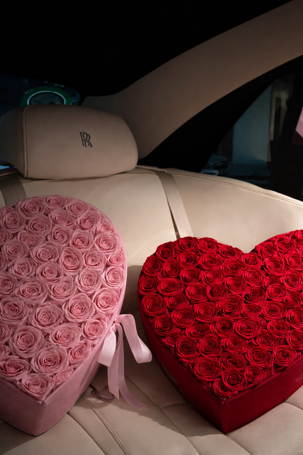 Pink and red heart-shaped rose arrangements on a cream car seat.